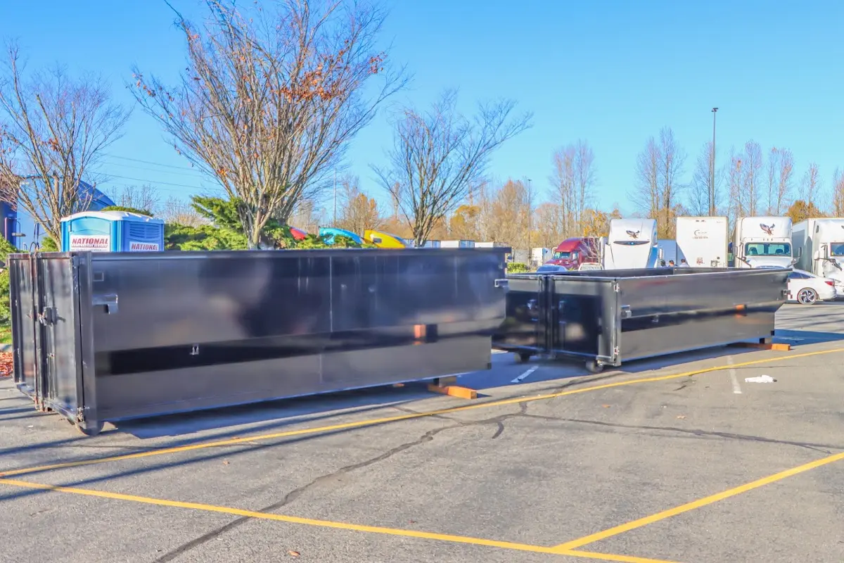 Professional dumpster rental service with roll-off container on residential driveway in Mableton